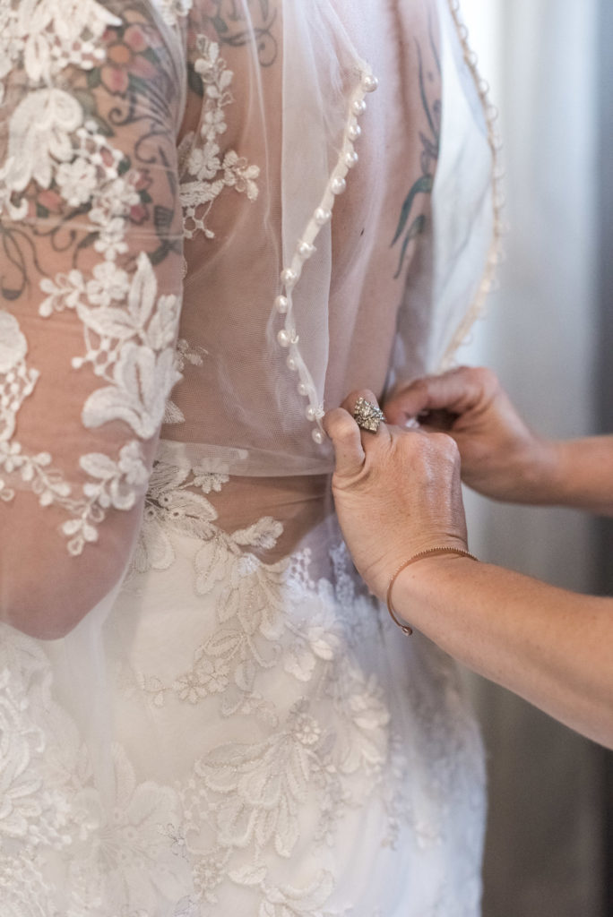 Bride getting ready in wedding dress with button back detail