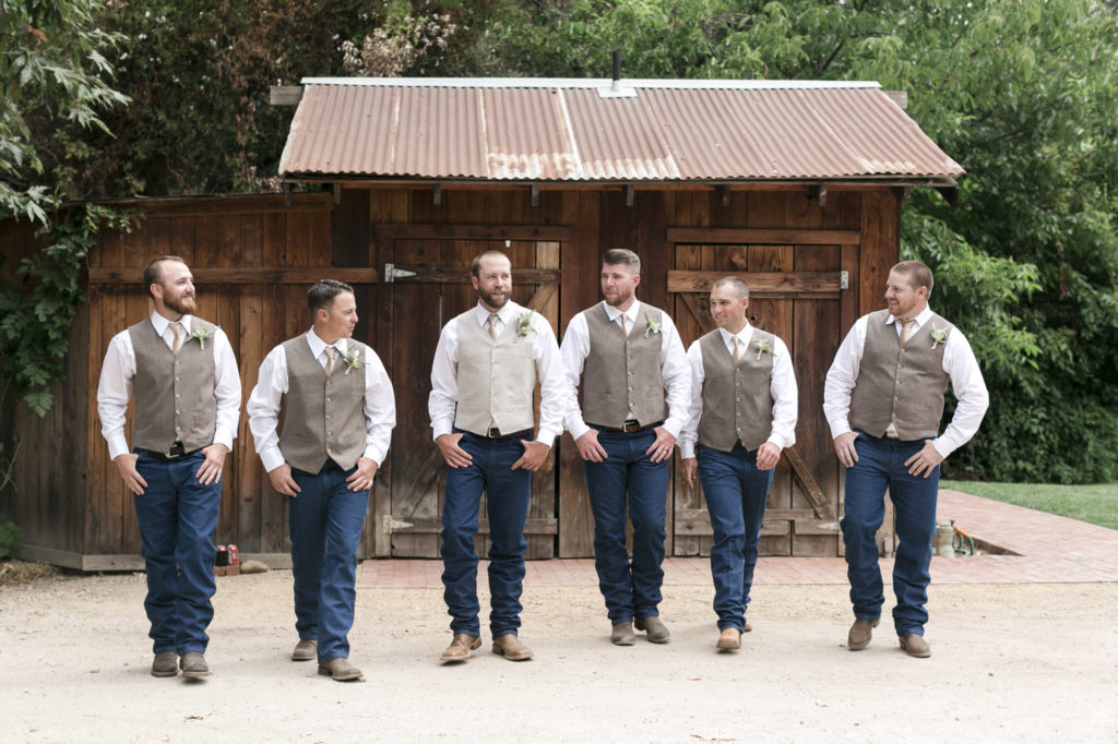 groom and groomsmen in vests denim and western boots