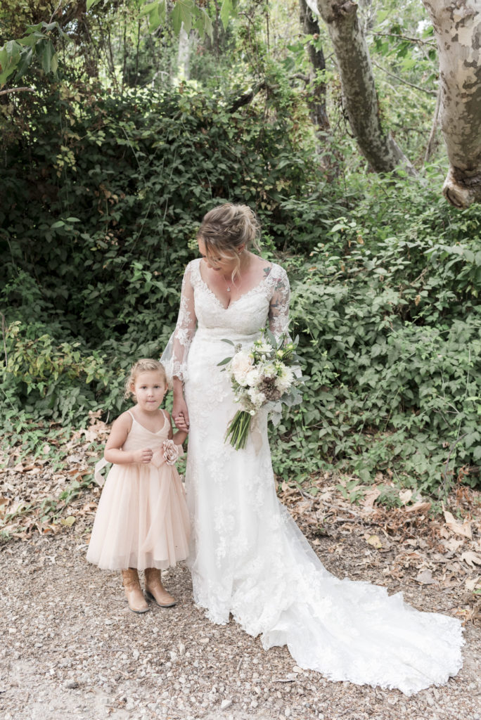 bride in vintage lace gown and flower girl in western boots