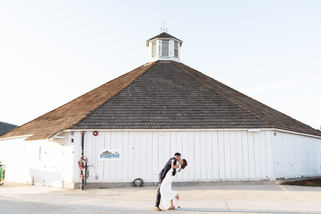 bride and groom in front of San Luis Obispo wedding venue the octagon barn by Kirsten Bullard Photography